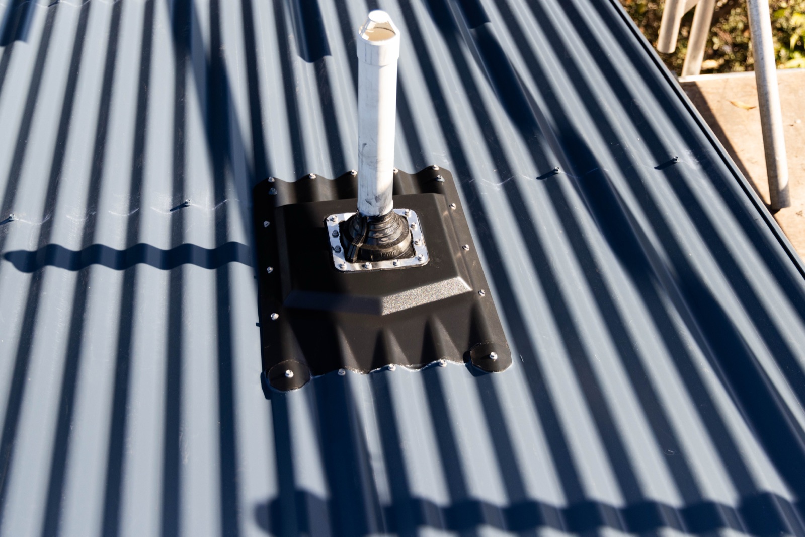 A Penenator flashing installed cleanly around a pipe penetration on a corrugated roof
